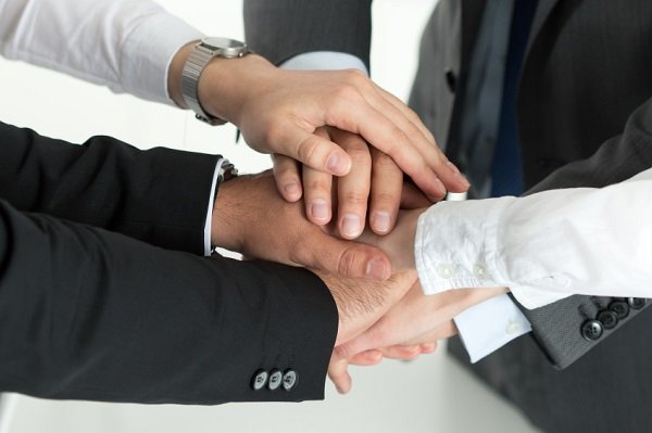 Closeup of business team showing unity with putting their hands